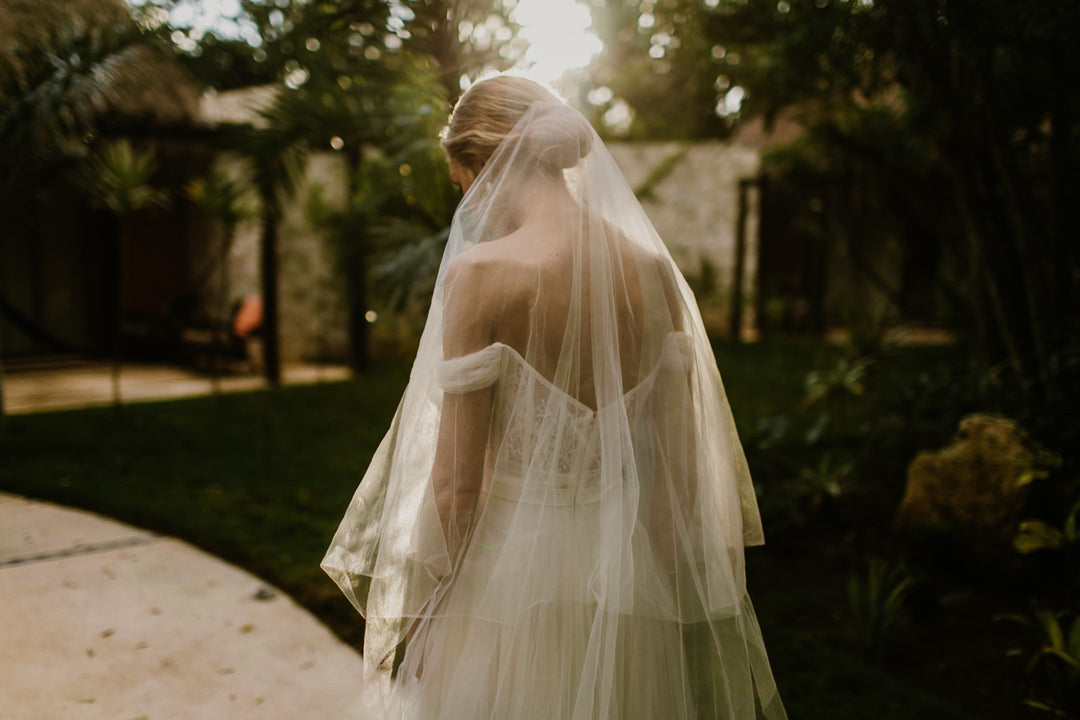 Bride wearing the ARIA sheer wedding veil with blusher with an off-the-shoulder wedding dress; the blusher is worn in the back and frames the brides updo.