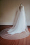 Back view focusing on the extensive, pearl-scattered chapel train of the ARIELLE bridal cape as it pools elegantly on the floor.