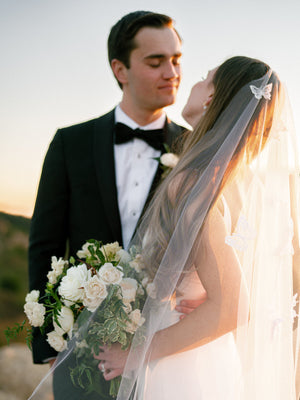 Close-up of the Dream butterfly wedding veil on a bride, showing lace butterflies against the sheer tulle background.