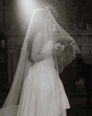 Profile photo of the Grace Pure Silk Blusher Veil on a bride, with the waist-length blusher pulled over the face, showing the classic and elegant silhouette. 