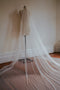 The Isabelle veil shown on dress dummy, in a 3/4 angle, showing the soft pull back effect of the silk tulle.