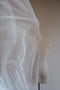 A motion photo of the Isabelle silk wedding veil being tossed in the air, highlighting the soft fluidity of the silk tulle.