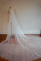 The Isabelle silk wedding veil shown on a dress mannequin, with the extra wide train of the veil fanned out on the floor.