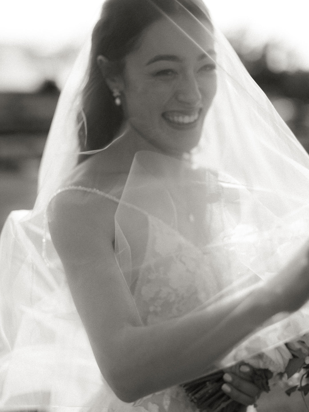 Bride wearing a wedding veil, black and white bridal portrait.