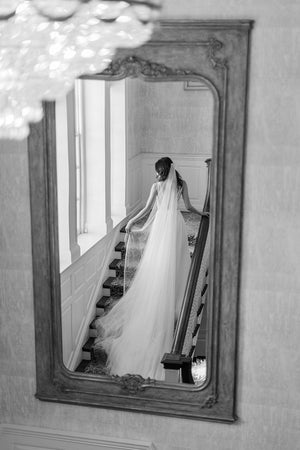 Bride wearing a cathedral silk wedding veil and lace wedding dress photographed on Graydon Hall staircase.