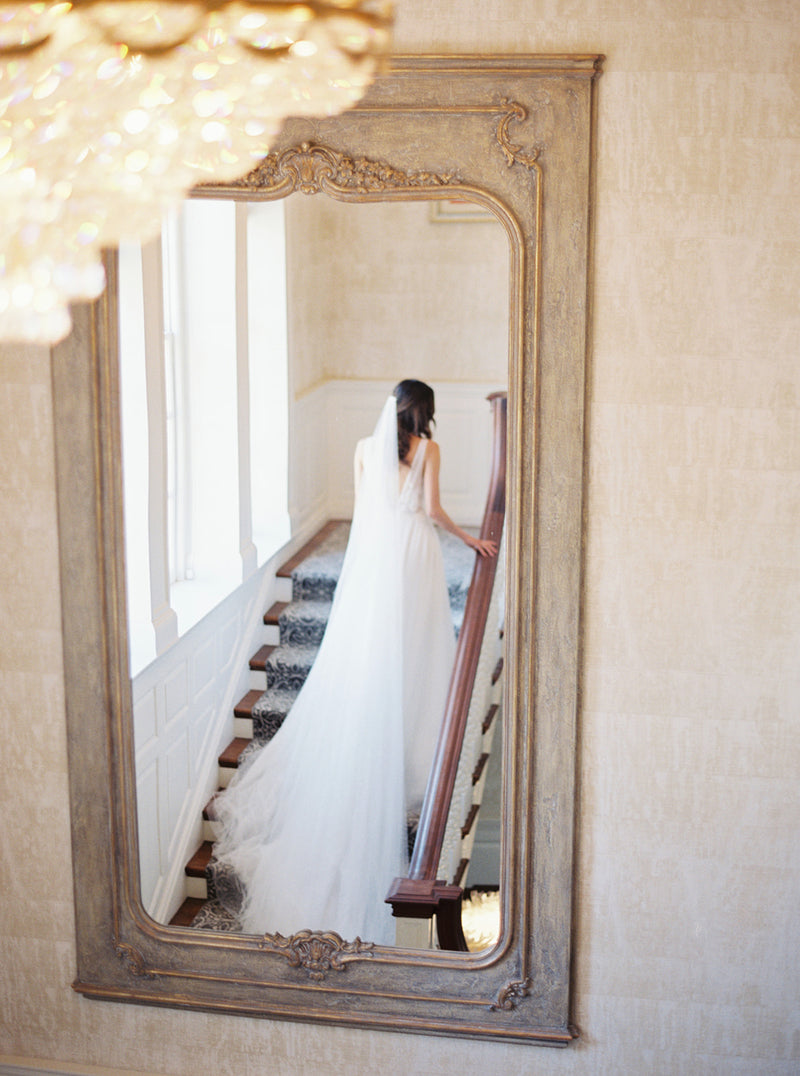 Cathedral silk wedding veil and dramatic wedding gown photographed on Graydon Hall staircase.