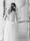 A bride wearing the REVERIE wedding veil with butterflies and lace wedding dress; she is standing in front of the mirror in the Graydon Hall bridal suite. 