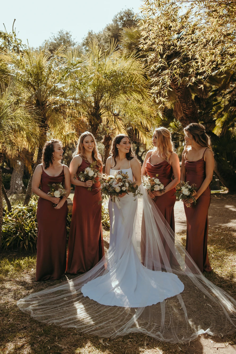 Bride wearing cathedral wedding veil. Group photo with bridesmaids.