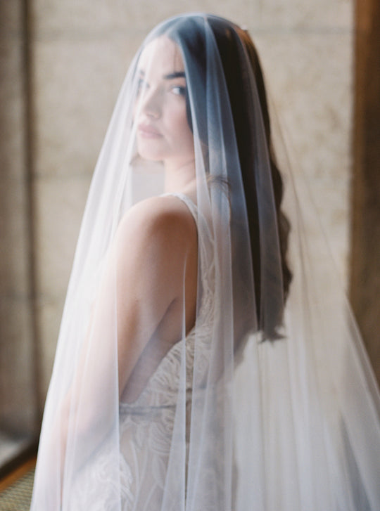 Wedding veil with long blusher. Bride looking over her shoulder.