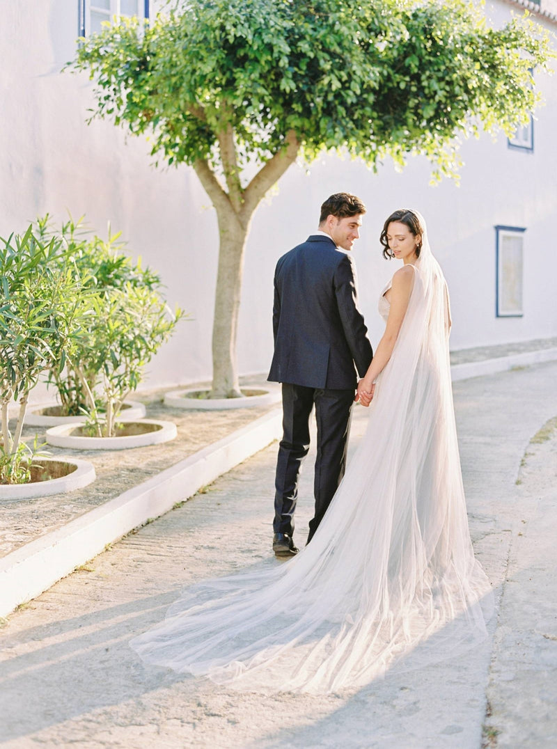 Back view of a bride wearing the Talitha wedding veil. The veil is fanned out on the ground to showcase the wide train.