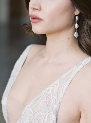 Bride wearing Tia long baroque pearl drop earrings with a lace gown, showcasing the 6.5cm drop length framing the face and complimenting the elegant neckline.