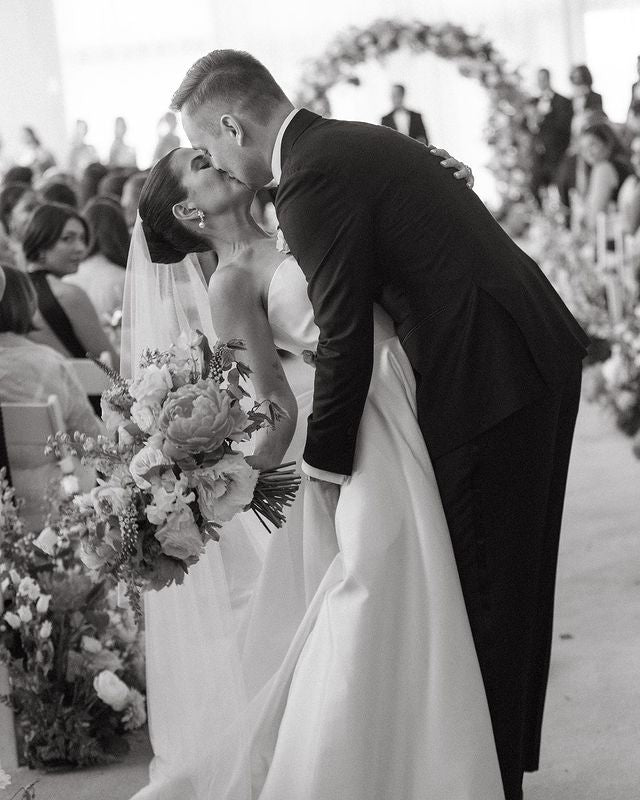 Black and white photo of a bride and groom at a wedding ceremony.