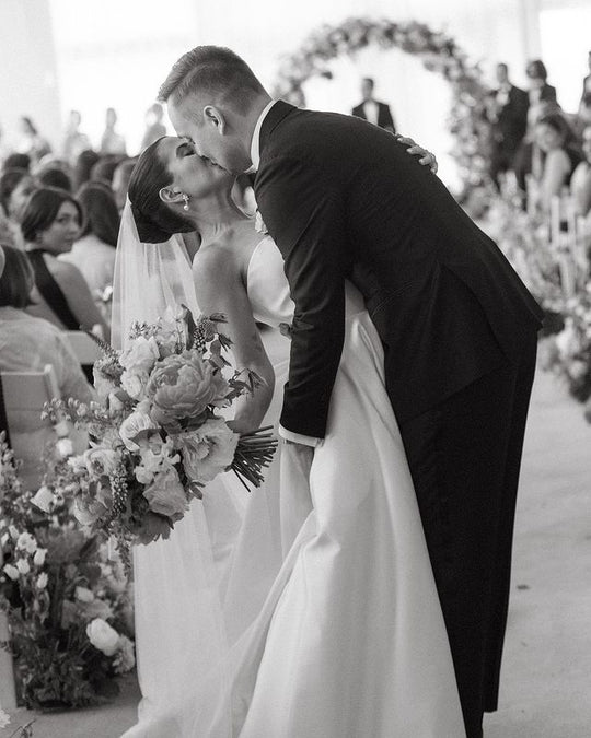 Black and white photo of a bride and groom at a wedding ceremony.