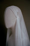 A close-up side view of the Lilybeth Juliet cap veil on a mannequin, highlighting the delicate hand-sewn gathering and the small metal comb used to securely anchor the silk tulle to the hair.