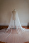The Lilybeth Juliet cap veil shown on a mannequin. The veil is fully fanned out on the ground, creating a wide, dramatic train.
