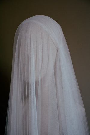 A side profile of a mannequin wearing the Lilybeth Juliet cap veil with the sheer silk blusher dropped delicately over the face.