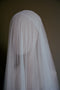 A side profile of a mannequin wearing the Lilybeth Juliet cap veil with the sheer silk blusher dropped delicately over the face.