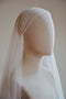 A three-quarter profile of a bridal mannequin wearing a vintage-style Juliet cap wedding veil. The elegant cap silhouette is softly hugging the crown of the head.