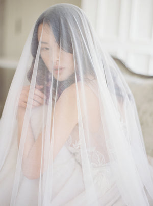 Intimate close-up of a veiled bride in Graydon Hall Manor. The Angelique Silk Drop Veil is worn over her face showcasing the delicate sheerness of the silk tulle.