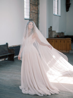 Bride turning gracefully while wearing the Grace Pure Silk Blusher Veil, highlighting the material's elegant movement.