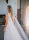 KAJA draped bridal cape veil styled with a lace gown and half up hairstyle.