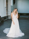 Full-body image of a bride modelling the KYOTO Floral Bridal Earrings and a flowy a-line lace wedding dress in a historic church.