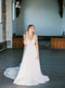 Full-length shot of a bride wearing the KYOTO Floral Bridal Earrings and a tulle bridal gown in a large, light-filled church.