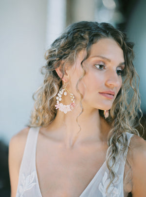 Close-up profile of a bride with a half-up hairstyle wearing the floral KYOTO Bridal Earrings, showcasing the delicate pearl and flower details.