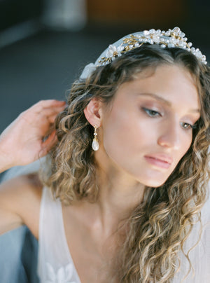 A medium close-up of a bride wearing the LYON pearl and crystal earrings and a delicate Juliet cap veil, focusing on the earring's subtle movement.