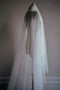 Full length view of the OPERA scattered pearl wedding veil draped on a dress form, showing the length of the blusher. 