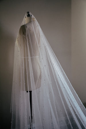 Back view of the OPERA veil on a dress form, showcasing the scattered pearls and the elegant drop style.
