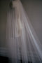 Close profile view of the sheer tulle and scattered large and small pearls on the OPERA wedding veil.