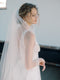 Close-up profile of a bride wearing the ROSANNA full wedding veil styled with a low updo. 