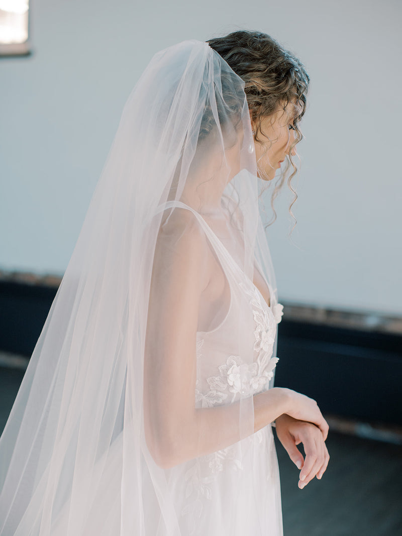 Fine art portrait of a bride wearing the Rosanna wedding veil with a low updo.