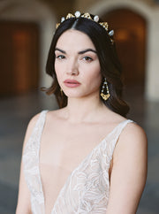 Delicate pearl bridal crown worn with hair down and long earrings.